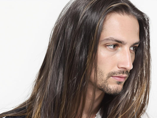 Man with long, sleek, dark hair, neutral background.