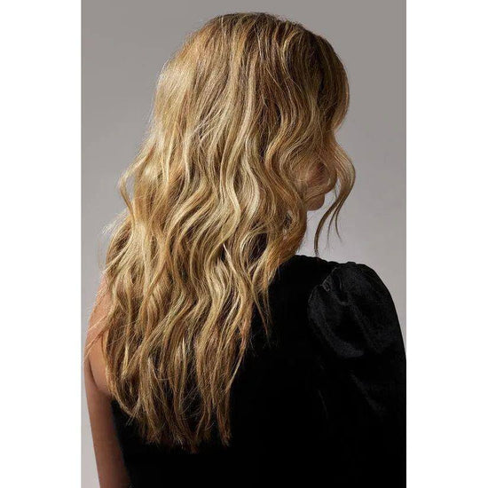 Woman with voluminous, wavy hair styled using Oribe Dry Texturizing Spray