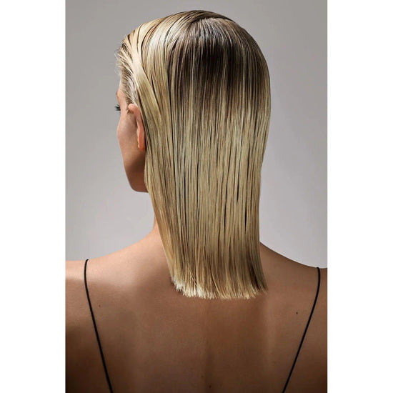 Woman with sleek, straight blonde hair styled using Oribe Gel Serum for a shiny and defined finish