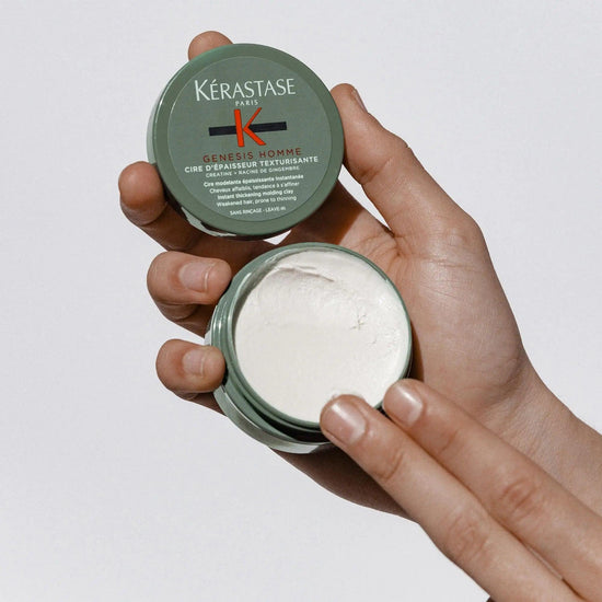 Kerastase Genesis Homme Cire d'Épaisseur Texturisante wax in hand for men's hair styling and texture.