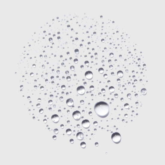 Close-up of Kerastase Genesis Homme thickening spray droplets.