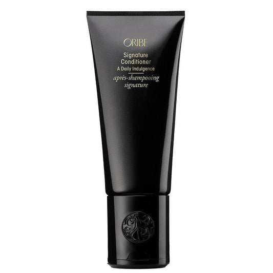 Oribe Signature Conditioner in black tube, hydrating formula for all hair types. Rejuvenates, detangles, and enhances natural shine.